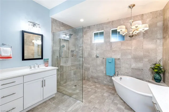 Floor to ceiling tile, designer light fixtures and light/bright vanities