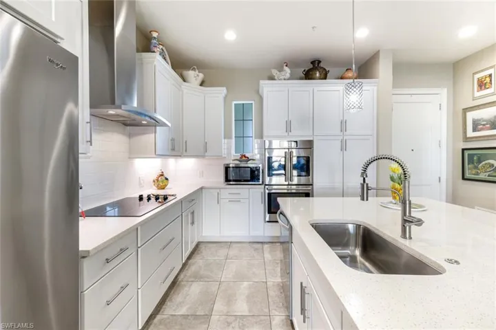 Well appointed kitchen with neutral quartz countertops, quality shaker cabinets and high-end stainless steel appliance