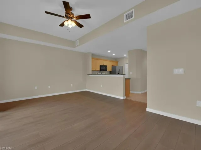 Living room featuring a tray ceiling and a ceiling fan. The space is designed for comfort and relaxation, enhanced by the architectural details of the tray ceiling and the functional addition of a ceiling fan for optimal air circulation.