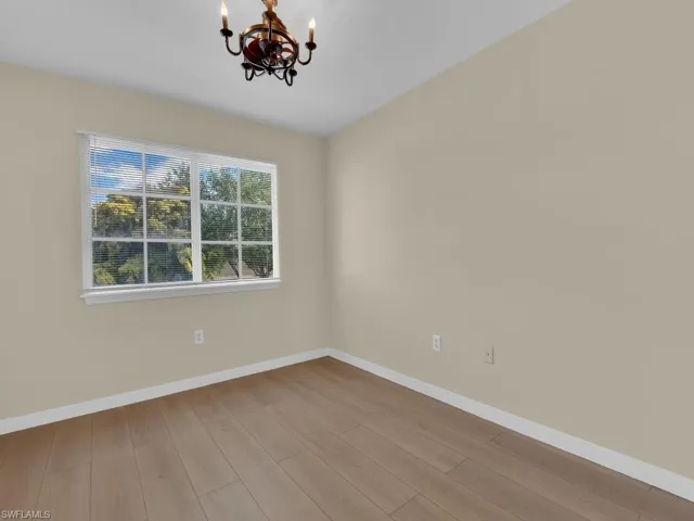 Description for the photo: This image showcases a Secondary Bedroom that features a unique and eye-catching Fandelier, a creative lighting fixture that combines the functionality of a fan with the elegance of a chandelier, adding both style and comfort to the space.