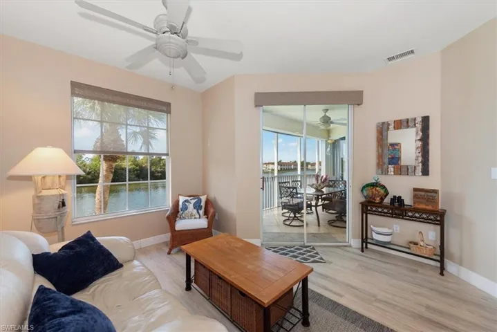 Living room with ceiling fan, light wood-style floors, and a water view