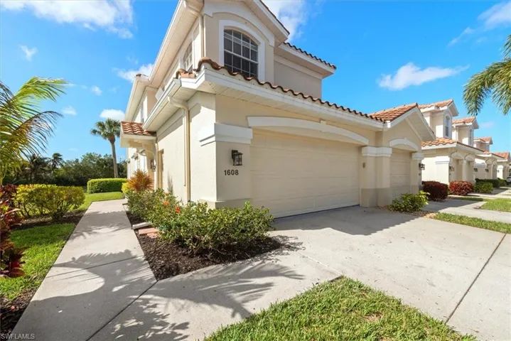 View of front of home with driveway, stucco siding, and a tile roof