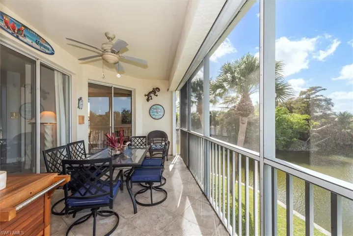 Sunroom with ceiling fan, outdoor dining area, and a water view