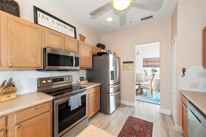 Kitchen featuring stainless steel appliances, backsplash, light countertops, light wood-style flooring, and recessed lighting