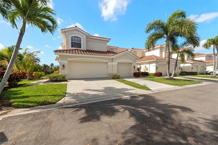 Mediterranean / spanish home with concrete driveway, stucco siding, a tiled roof, a garage, and a front lawn
