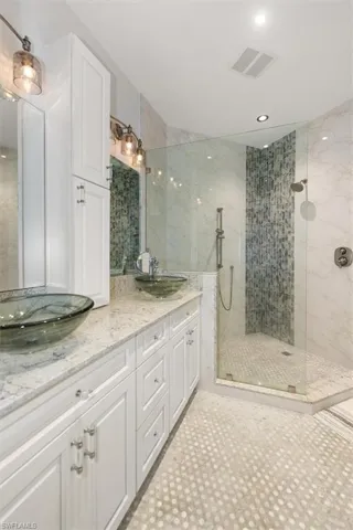 Full bath featuring double vanity, walk in shower, recessed lighting, and light tile patterned floors