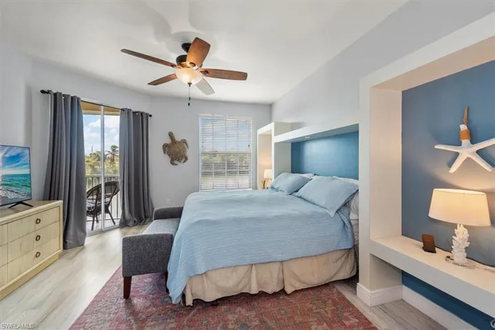 Bedroom featuring access to exterior, light wood finished floors, and a ceiling fan