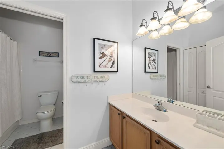 Bathroom with a shower with curtain, vanity, and light tile patterned floors