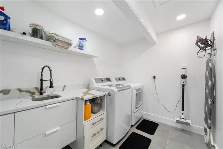 Laundry area featuring sink, cabinets, and independent washer and dryer