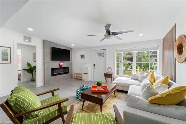 Living room featuring ceiling fan and a tile fireplace