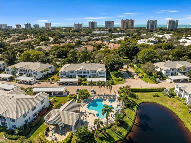 Aerial perspective of suburban area featuring city skyline and a nearby body of water