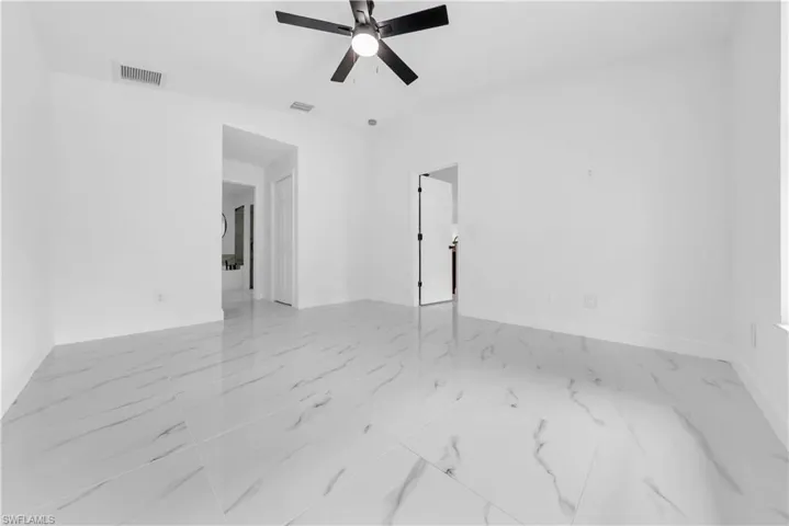 Spare room with a ceiling fan and light marble finish flooring