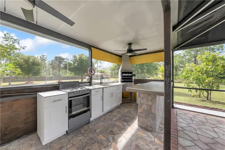 View of patio / terrace with area for grilling and a ceiling fan