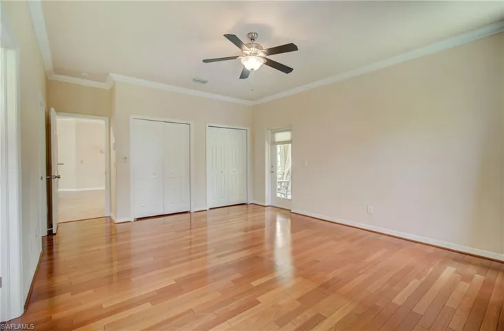 Unfurnished bedroom with two closets, ceiling fan, light hardwood / wood-style floors, and ornamental molding