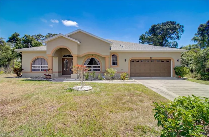 Ranch-style home featuring a garage and a front yard