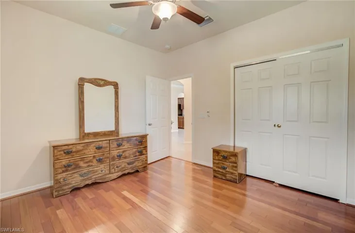 Unfurnished bedroom featuring hardwood / wood-style flooring, a closet, and ceiling fan