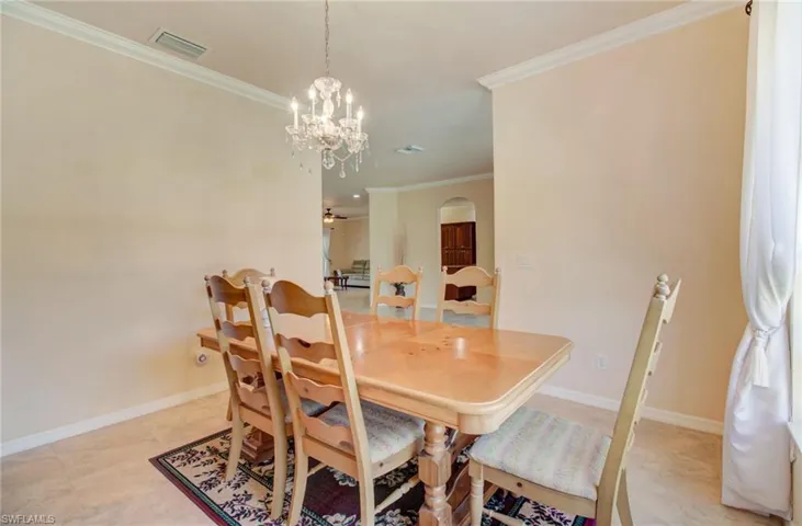 Dining space featuring a chandelier, ornamental molding, and light tile floors