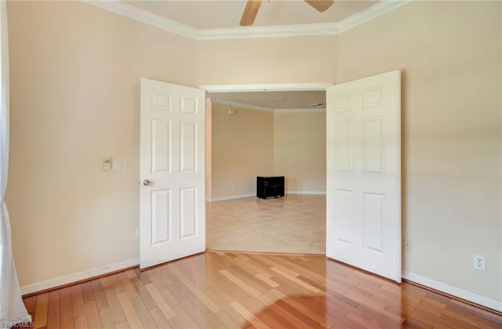 Tiled empty room with crown molding and ceiling fan