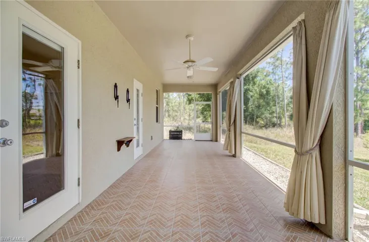 Unfurnished sunroom featuring ceiling fan