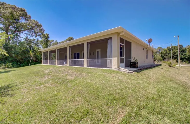 Back of house with a sunroom and a lawn