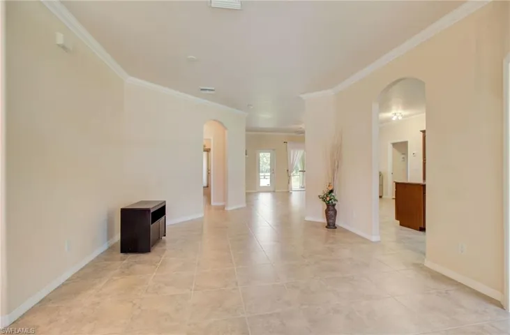 Spare room featuring ornamental molding and light tile flooring