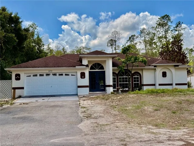 Ranch-style home with stucco siding, a garage, asphalt driveway, and french doors