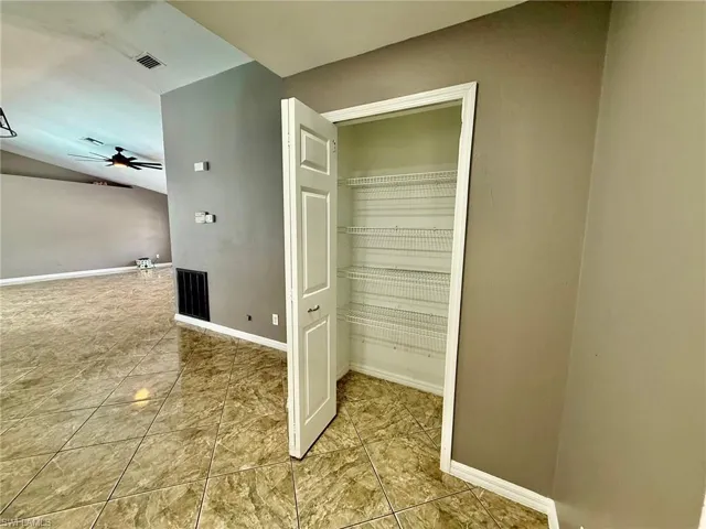 Laundry area with a sink and light tile patterned floors