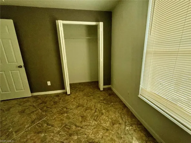 Empty room featuring ceiling fan and baseboards