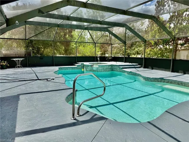 Integrated pool / hot tub featuring a patio, glass enclosure, and a sunroom