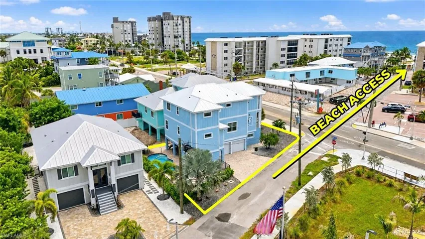 Coastal property featuring two multi-story residences, a private pool, and a paved driveway