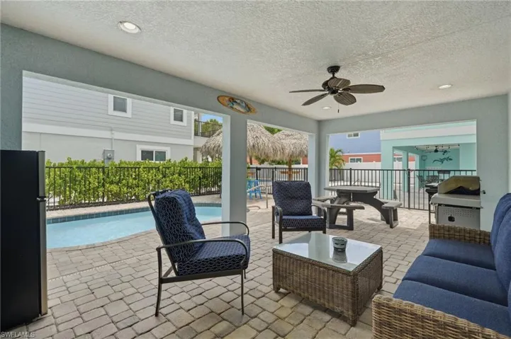 Covered patio featuring recessed lighting, a ceiling fan, and paver flooring - Virtually Edited Image