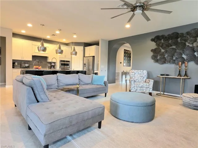 Living area featuring arched walkways, ceiling fan, and recessed lighting