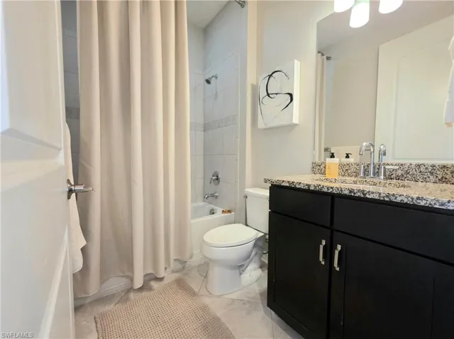 Bathroom with vanity and shower / bath combo with shower curtain
