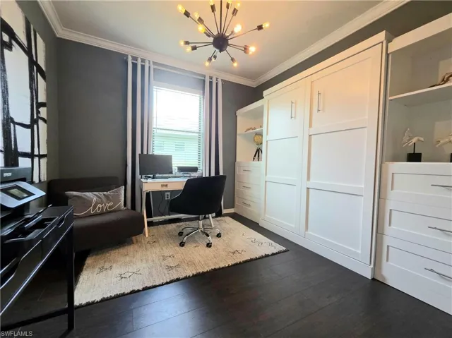 Office space featuring crown molding, dark wood finished floors, and hanging lights