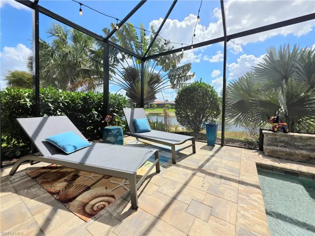 View of patio / terrace featuring a water view, a sunroom, and a lanai