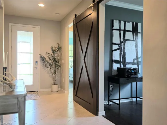 Entryway with a barn door and tile patterned flooring