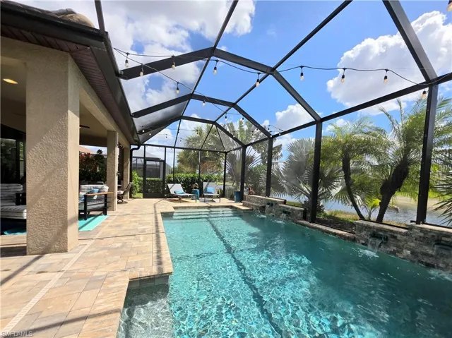 Outdoor pool featuring a sunroom, a patio, and a lanai