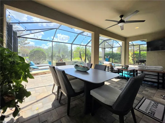 View of patio with a sunroom, an outdoor pool, an outdoor living / dining area, and ceiling fan