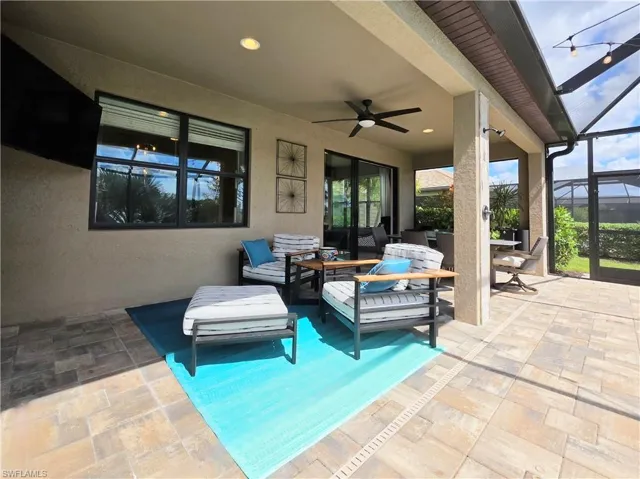 View of patio / terrace featuring a lanai, outdoor seating, a sunroom, and a ceiling fan