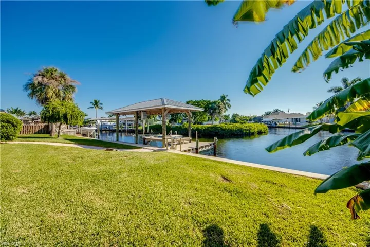 Well manicured backyard with Covered Boat dock and intersecting views of waterway!