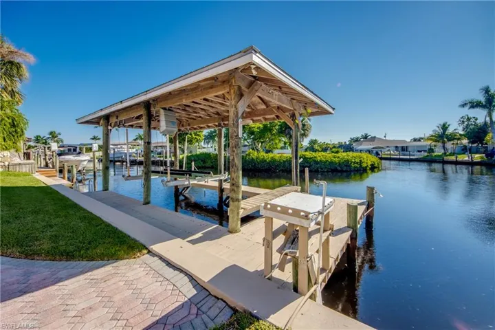 Metal roof covered boat lift with walk around dock, seawall and fish cleaning station. Wired for Snook light. Only 9 houses to the Caloosahatchee Intracoastal Waterway! Intersecting canal views. Brick paved walkway from the home.