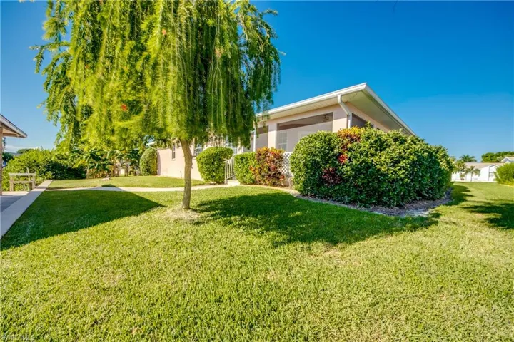Well manicured backyard with Covered Boat dock and intersecting views of waterway to left and Home to right!