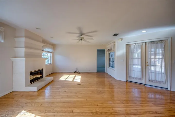 Great room and Fireplace. French doors to the right lead to the huge Privacy walled and screened Courtyard. Master Suite off the Great room. 5 windows and 2 sets of french doors create a light filled great room.