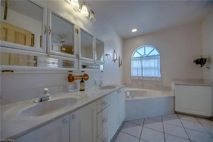 Primary en-suite bathroom is spacious and features double sinks and a large vanity, Soaking tub, linen closet, separate water closet and a walk-in shower. There is French door leading to the Private courtyard .