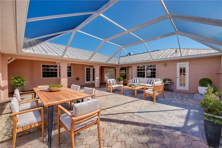 Virtually Staged. Huge Private Brick paver Courtyard with covered and open screened sitting areas! Offers entry to the Cabana Guest Suite and the main home! So many possibilities for this lovely area!