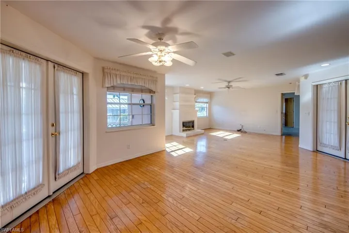 Dining area looking toward the Great room and Fireplace. French doors to left lead to the Covered and Screened Lanai. French doors to the right lead to the huge Privacy walled and screened Courtyard.