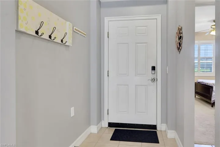 Entryway featuring tile patterned flooring and ceiling fan