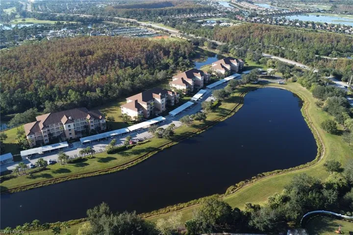 Aerial overview of property's location featuring a nearby body of water and a heavily wooded area