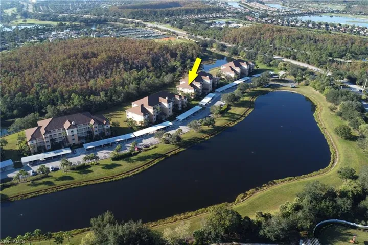 View of property location with a large body of water and a heavily wooded area