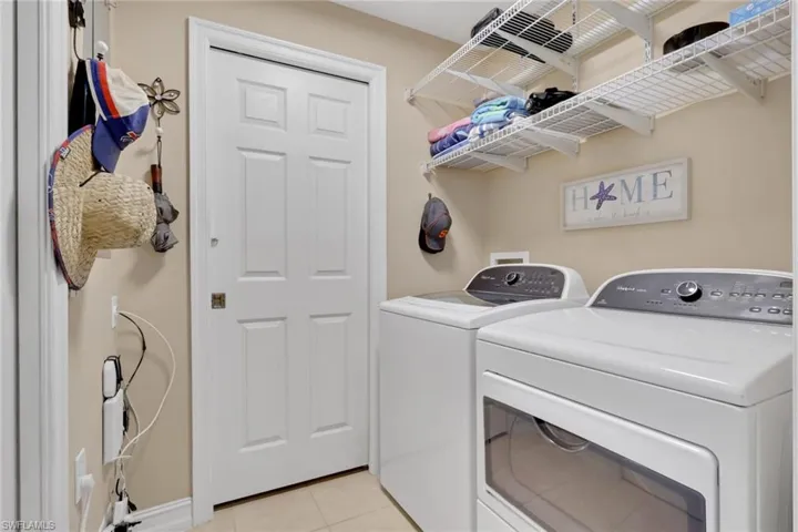 Laundry area featuring washer and dryer and light tile patterned flooring